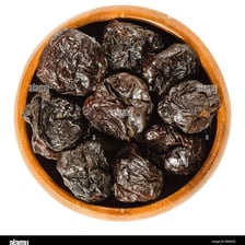 Dried prunes displayed in a bowl.