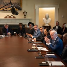 Government officials gathered in an official office.