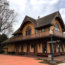 A railway depot building beside train tracks.