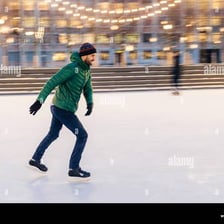 A person skating across an ice rink.