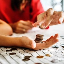 A person sorting and counting a small pile of coins.
