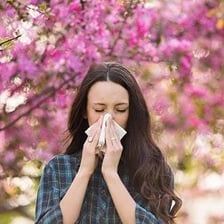 A person covering their nose and mouth while sneezing.