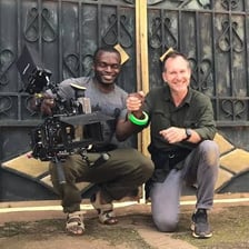 A film director signaling to stop a scene on a movie set.