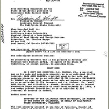 A signed real estate deed document beside a house key