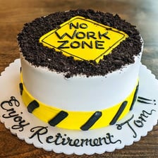 A bakery worker spreading icing on a cake.