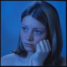 A person appearing sad in blue-toned lighting.