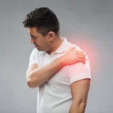 A person holding a painful shoulder.