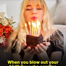 A person blowing out birthday candles while making a wish.