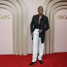 An Oscar nominee posing on a film-awards red carpet.