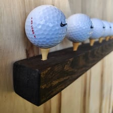 A golf ball resting on a tee on a golf course