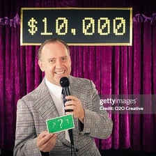 A host speaking into a microphone on a game-show stage