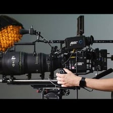 A film camera arranged with lights and equipment on a movie set