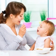 An adult feeding a baby