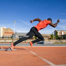 A sprinter running quickly on an athletic track.