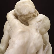 Rodin’s marble sculpture The Kiss showing an embracing couple.