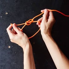 Hands using rope to tie something securely