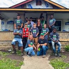 A group of people indicating a house they share