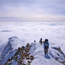 A person climbing upward on a mountain trail.