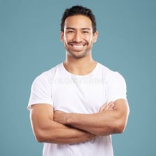 A person standing with a confident expression and folded arms.