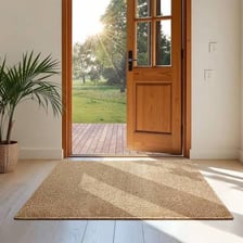 A small woven rug lying on the floor beside a doorway.
