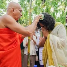 A person applying oil during an anointing ceremony