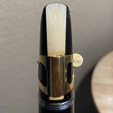A clarinet mouthpiece with its reed visible