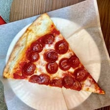 A single pizza slice served on a plate
