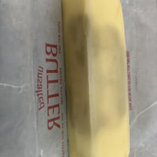 A close-up of visibly spoiled butter representing a rancid taste or smell.