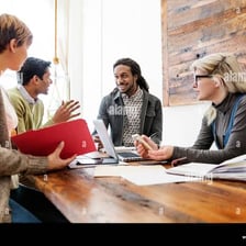 Several people engaged in a discussion around a table.