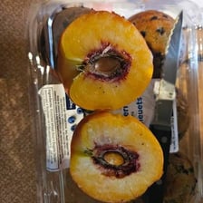 A sliced peach with its central pit visible