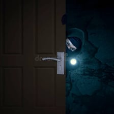 A person moving quietly and secretly through a doorway.