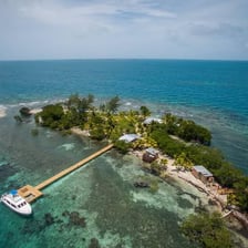 A small sandy coral cay surrounded by turquoise water.