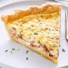 A baked quiche showing its egg-based custard filling.