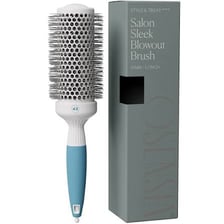 A hairbrush being used to style hair in a salon.