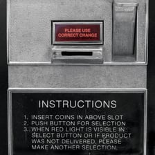A close-up view of a coin being inserted into a machine slot.