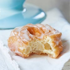 A glazed donut beside a ridged cruller.