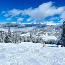 Skiers traveling down a snow-covered slope