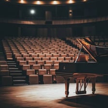 A grand piano on a concert-hall stage.