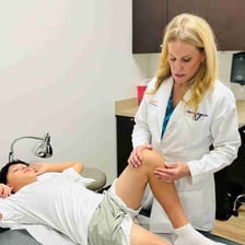 An orthopedic doctor examining a patient’s knee.