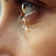 A tear drop visible on the edge of a human eye.