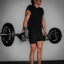 A person performing a weightlifting exercise in a gym.