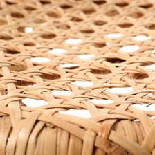 A chair with a woven cane seat and back