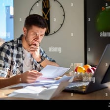 A person reviewing unpaid bills to represent owing money