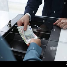 A person handing money to a cashier.