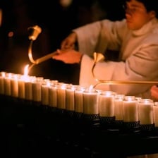 A person using a match to light a candle.