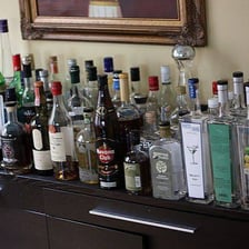 An assortment of alcoholic drinks on a bar.