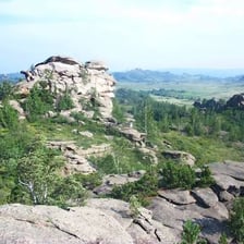 A rocky crag rising above a hilly landscape