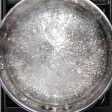 Water visibly boiling in a pot.