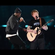 Singers performing music on a stage.