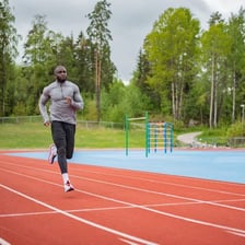 A runner moving around an outdoor track
